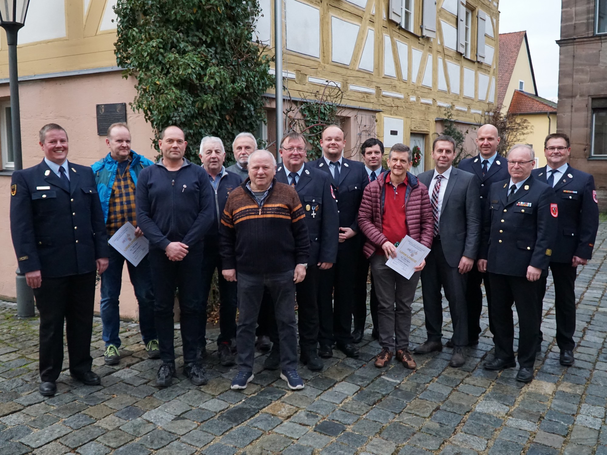 Bürgermeister Ben Schwarz mit der Vereinsführung, den Führungskräften der Feuerwehr und den geehrten Mitgliedern